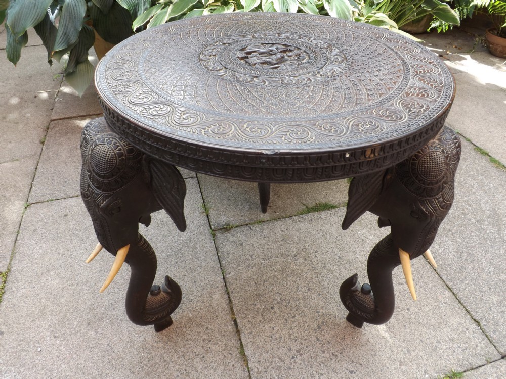 c19th indian finely carved teak circular occasional table on elephant trunk supports