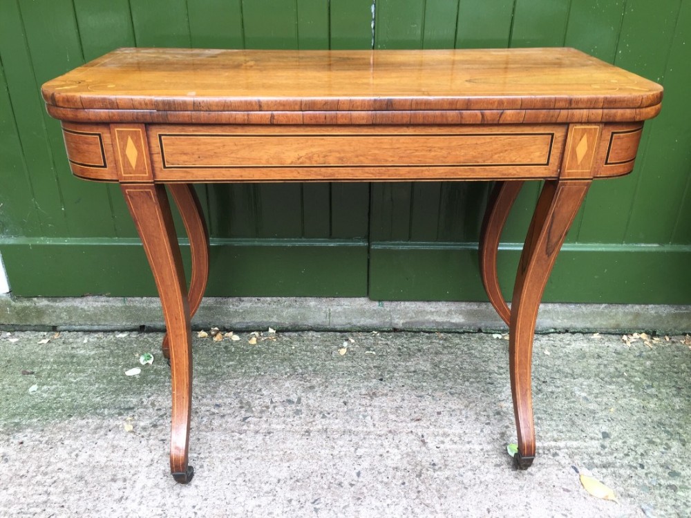 early c19th regency period inlaid rosewood foldover card or gaming table raised on sabre legs