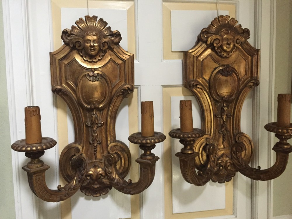 large and impressive pair of early c20th french or italian carved giltwood twin branch walllights or appliqus in the mid c17th louis xiv manner