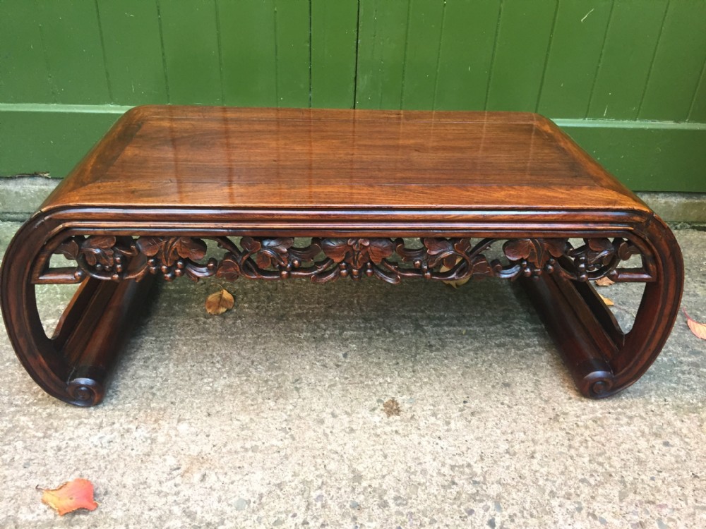 late c19thearly c20th chinese qing dynasty carved hardwood low 'kang' or opium table of scrollend form