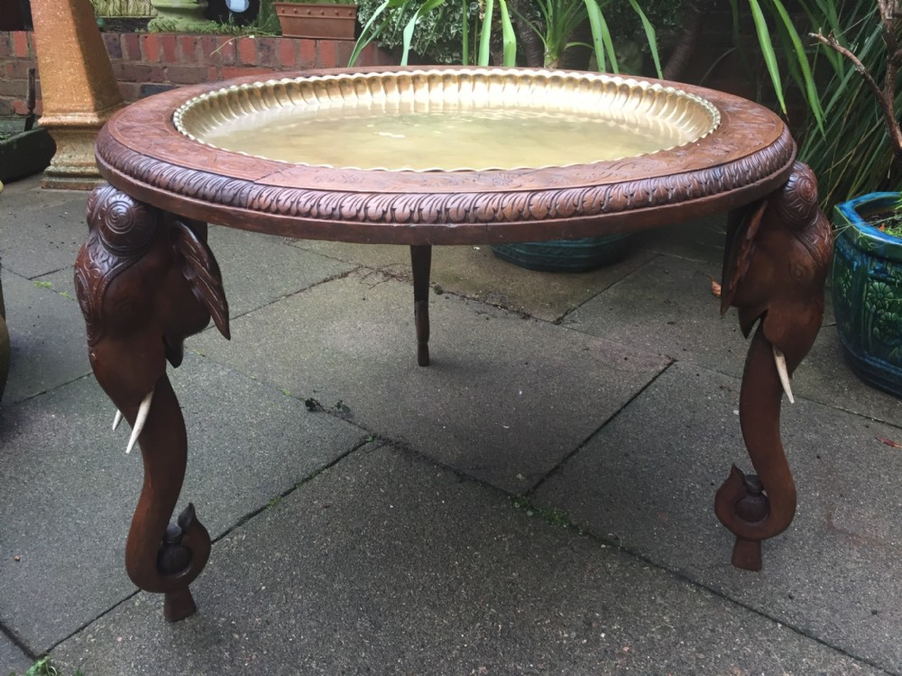 late c19th indian circular carved teak table on carved elephant supports with brass tray centre