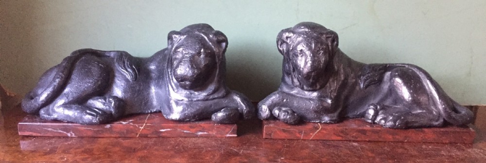 pair of early c19th 'grand tour' souvenir patinated castlead lions mounted upon rouge griotte marble plinth bases copies of the egyptian lions from the vatican rome