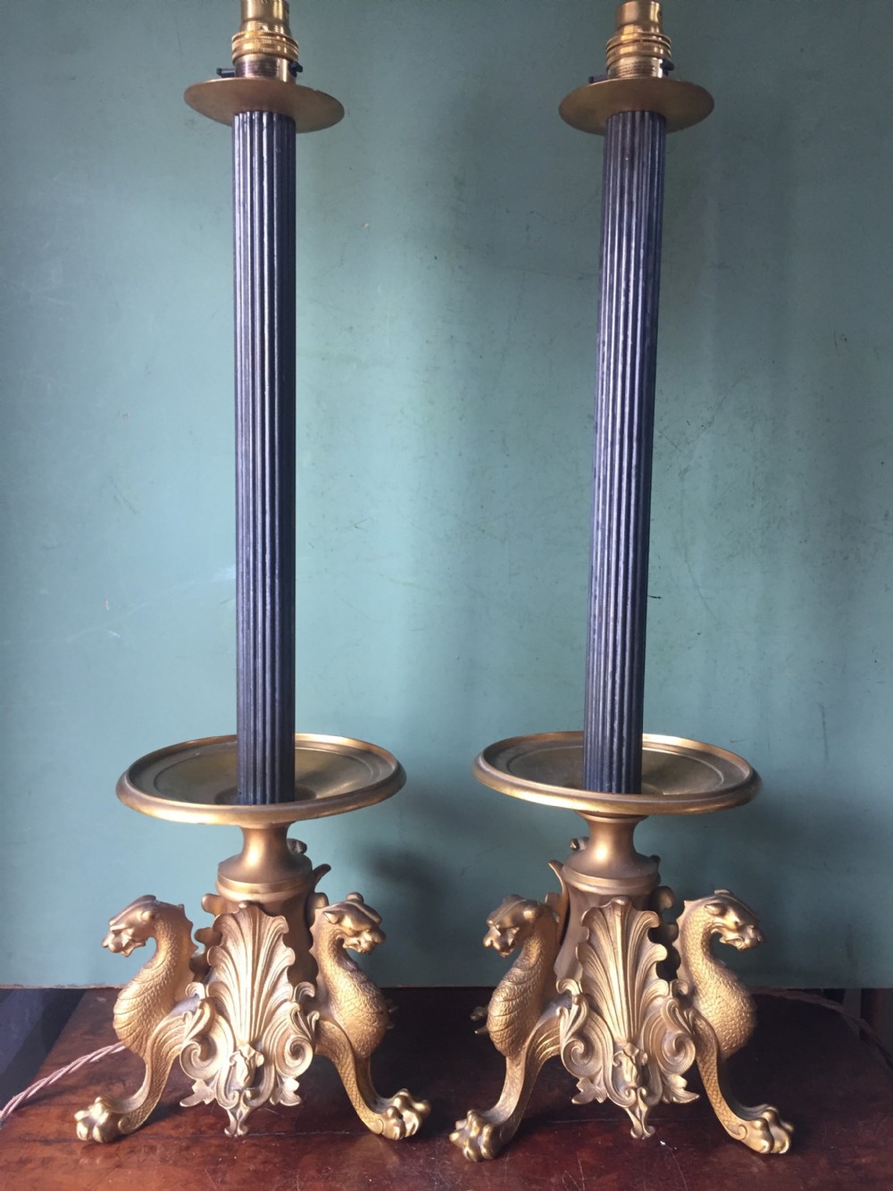 pair of late c19th french gilt and patinated bronze lamps raised on triform griffin supports