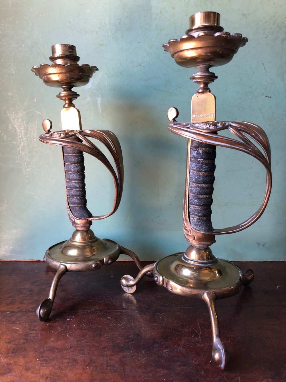 pair of c19th victorian period gilded and lacquered brass military design candlesticks with swordhilt bodies