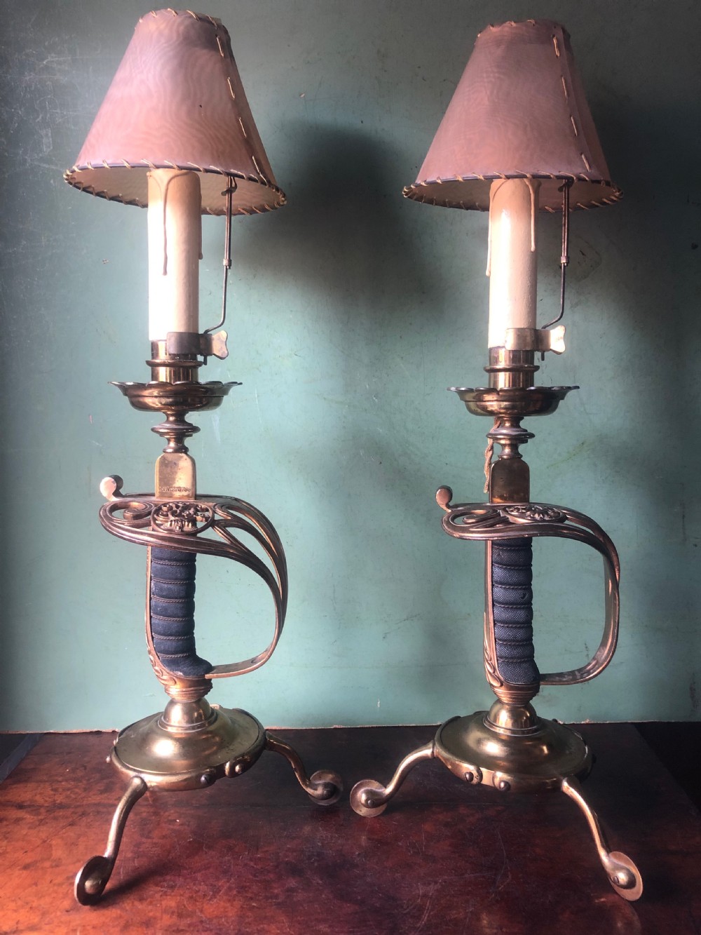pair of decorative late c19th gilded brass candlelamps modelled as basketguard cavalry dress swords