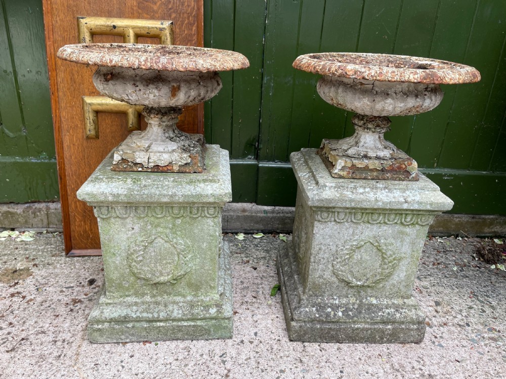 pair of smaller scale early c19th castiron tazza style garden or terrace urns on composition stone plinth bases