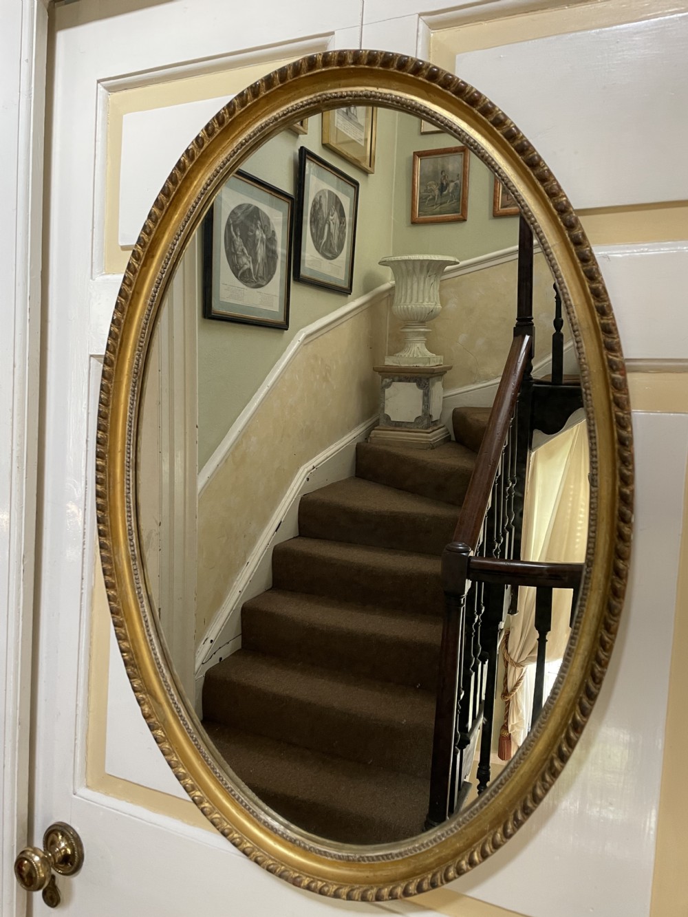 late c19th giltwood framed oval mirror of late c18th george iii period restrained design