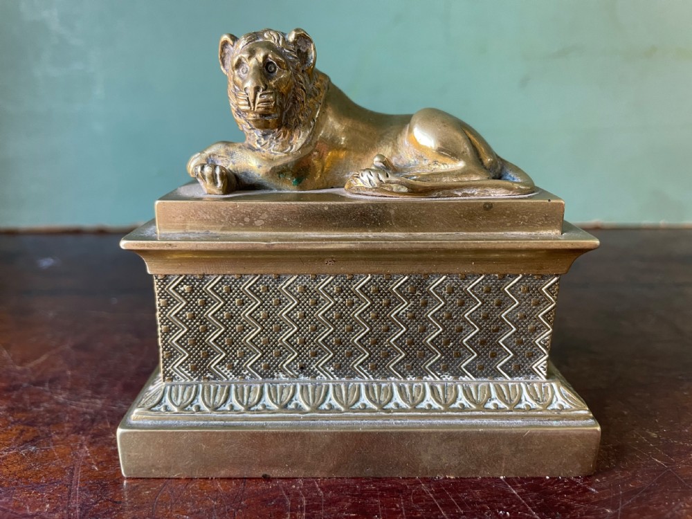 early c19th regency period miniature giltbrass desktop inkstand modelled as a recumbent lion mounted upon a plinth base