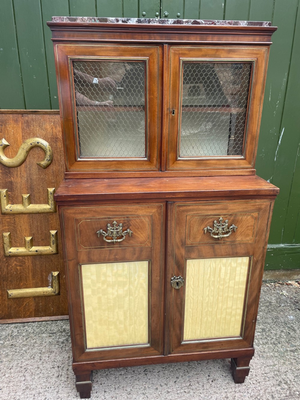 elegant early c19th smallscale mahogany 4 door 2part glazed cabinet having brass line inlay and brass mouldings together with a rosso levanto marble top