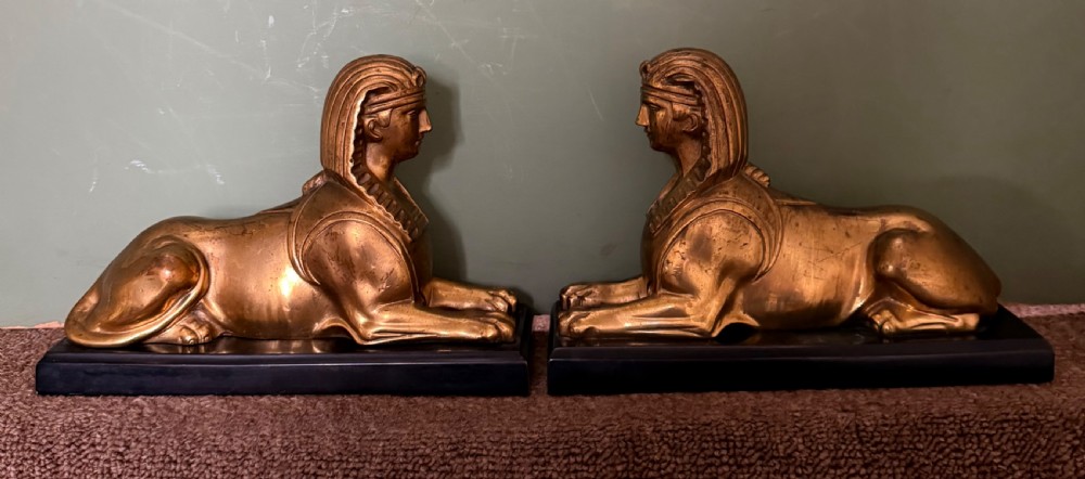 pair of early c19th gilded bronze studies of recumbent sphinxes on rectangular patinated bronze plinth bases