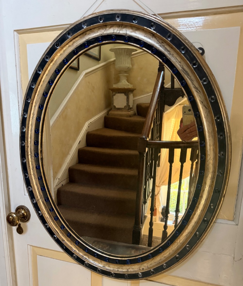 scarce larger scale early c19th irish ebonised and silvergilt framed oval mirror with clear facetted glass jewels and colbalt blue glass cabochons